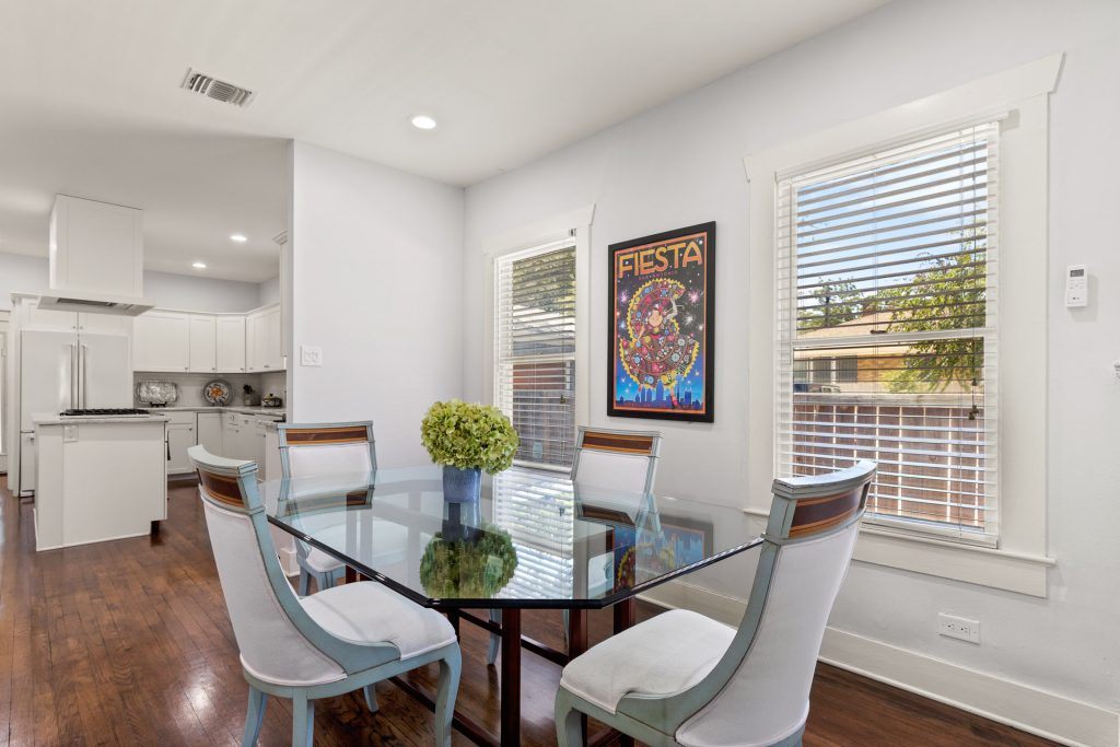 Bright dining room in an iTrip San Antonio vacation rental, featuring colorful Fiesta poster from past celebrations.