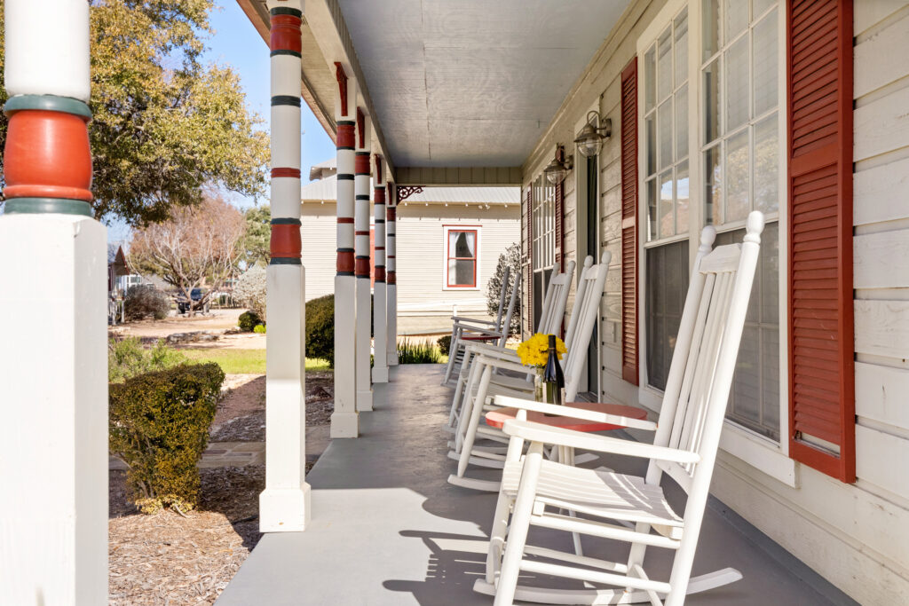 Front porch with rocking chairs at a vacation rental in Gruene, Texas, offering a relaxing stay near Gruene Hall and local festivals.