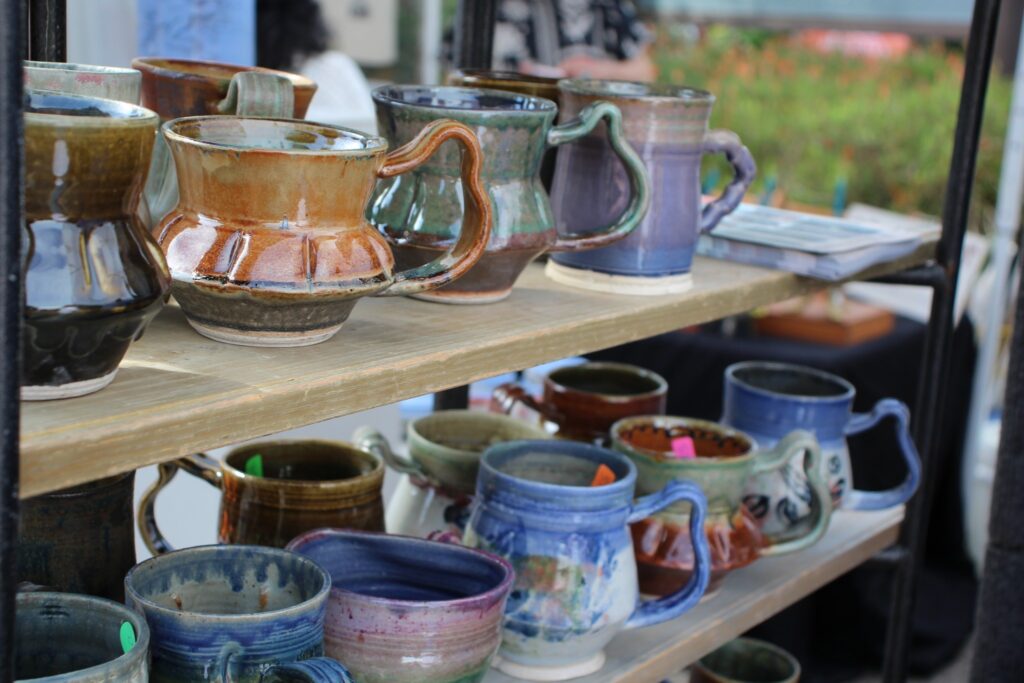 Colorful handcrafted clay mugs at the Texas Clay Festival in Gruene, Texas, showcasing local pottery and artisan craftsmanship.