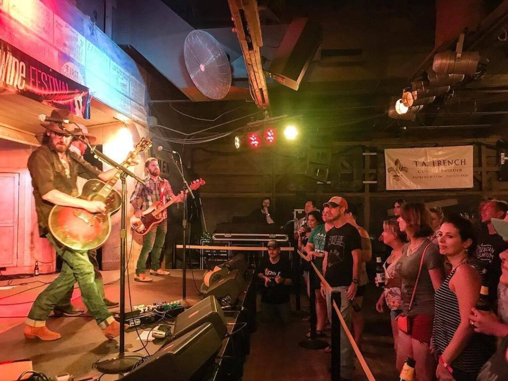 Band performing on stage at Gruene Hall during the Gruene Wine and Music Festival with crowd enjoying live Texas music.